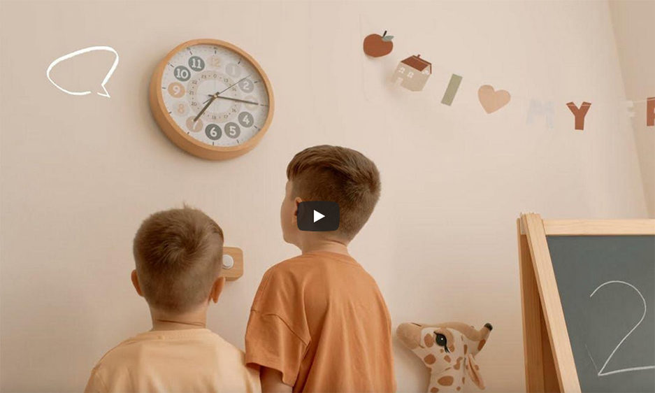 Spielende Kinder vor einer großen Uhr